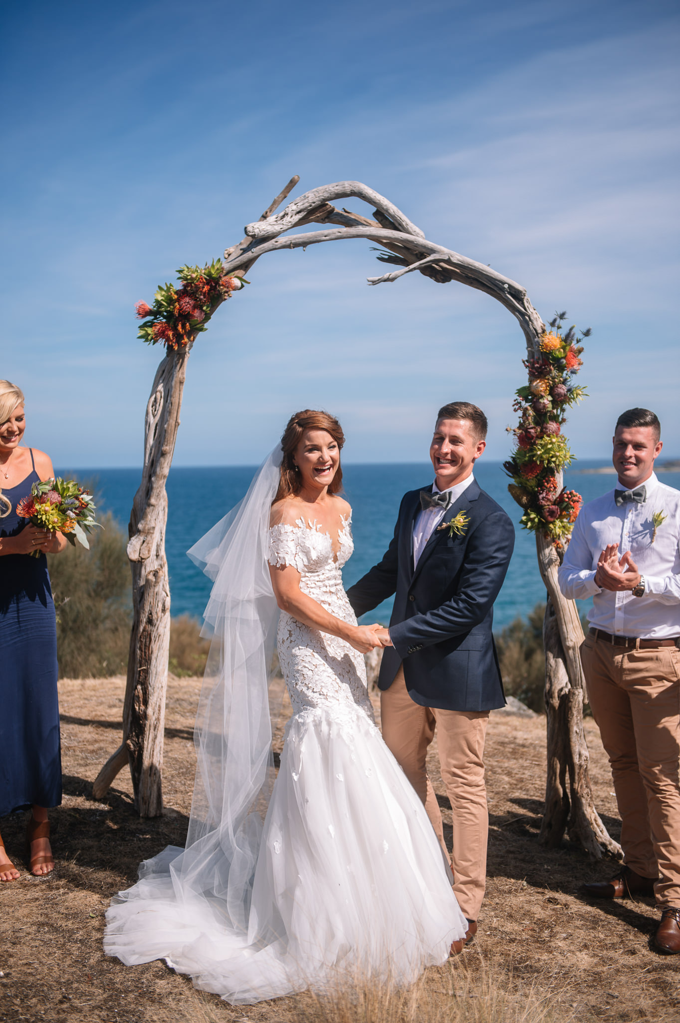  Coastal wedding under an arch of locally found driftwood 
