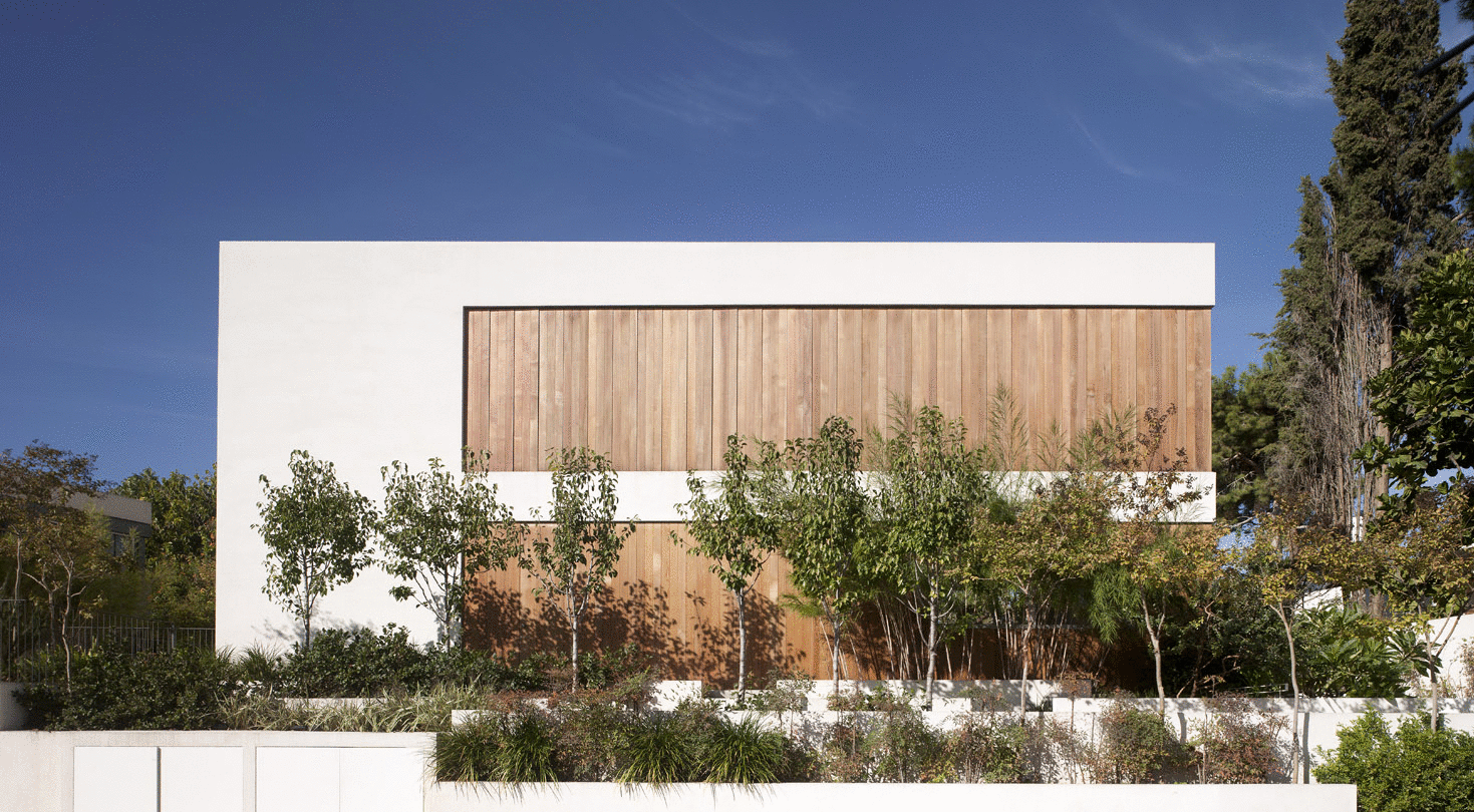 BRISE SOLEIL HOUSE The costumer requested a living room, bed rooms, a kitchen a garden and all the things costumer usually ask for. Only then arrived a surprising turn in the plot. The costumers also requested the project to be a "Bulldog". They did not mean the dog. They were talking about the essence, the character. With that word in mind, we started our design mission. Three years later standing there was the Bulldog. Firm, solid but knows how to evoke a smile. When needed. The project's interface with the street is through a brise soleil (vertical shutters system) made of cedar wood. The brise soleil allows controlling the levels of exposure of the indoor to the street. From time to time, according to the needs of the residents, the brise soleil system can change from open to closed and vice versa. The connection between indoor and outdoor has never been more flexible. The electrical system, which was developed independently, can control the level of the privacy inside the house, the levels of natural light and the energy consumption. Site area: 550 sqm | built area: 350 sqm Architect in charge: Shirly Marko | Project management: Nati Marcovich | Brise Soleil system: Anderman Architects, Mark Witson, "Galil Technologies" | Photographs: Amit Geron