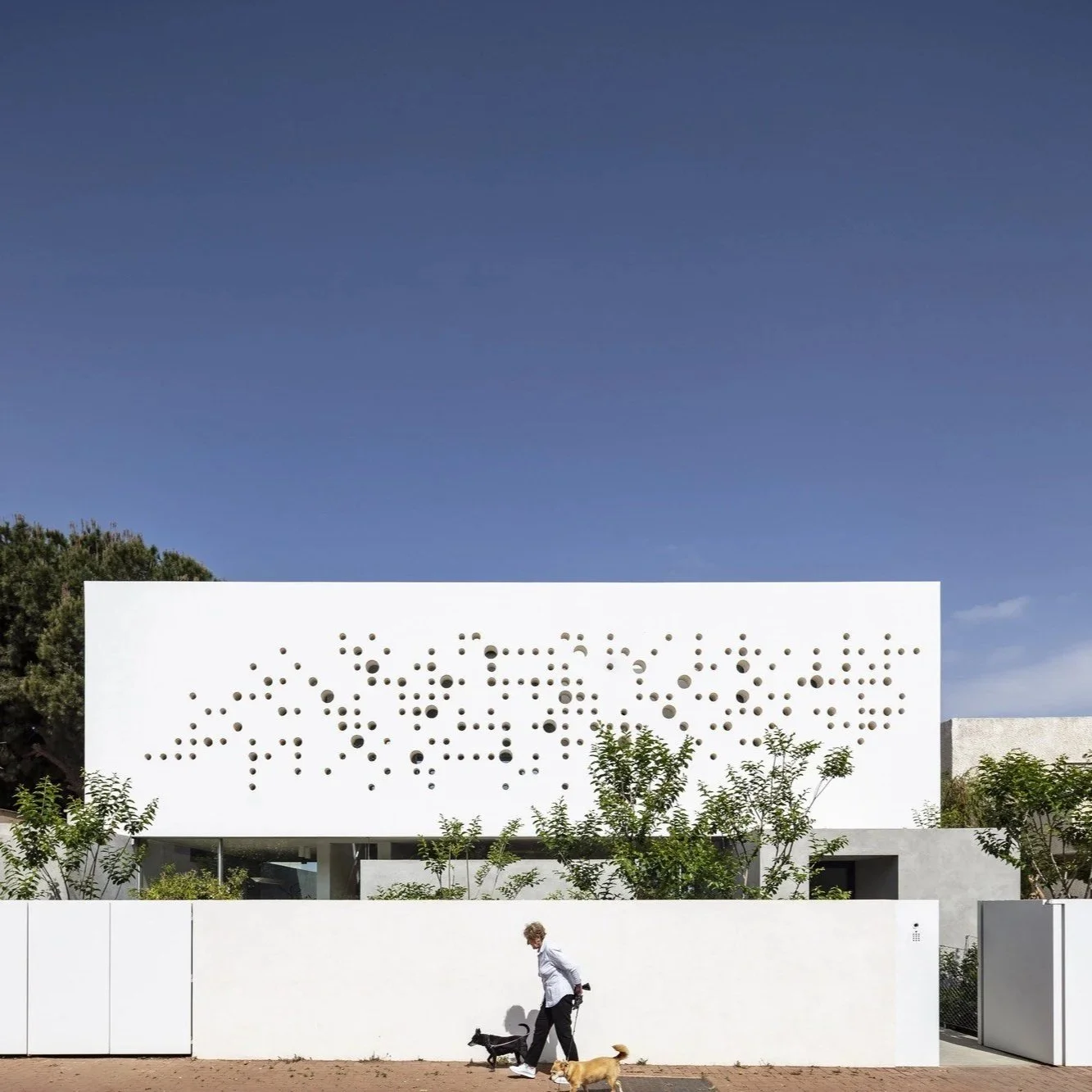 ArchDaily: Round Edge House. An Anderman Architects residence in Ramhash, shaped by a perforated concrete façade balancing privacy and daylight..
