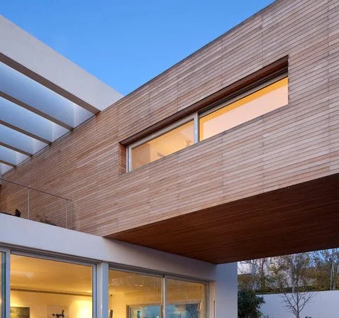 Xnet: The Floating Cube House. An Anderman Architects residence whose elevated upper volume creates a light, sculptural presence above the garden and entrance level.