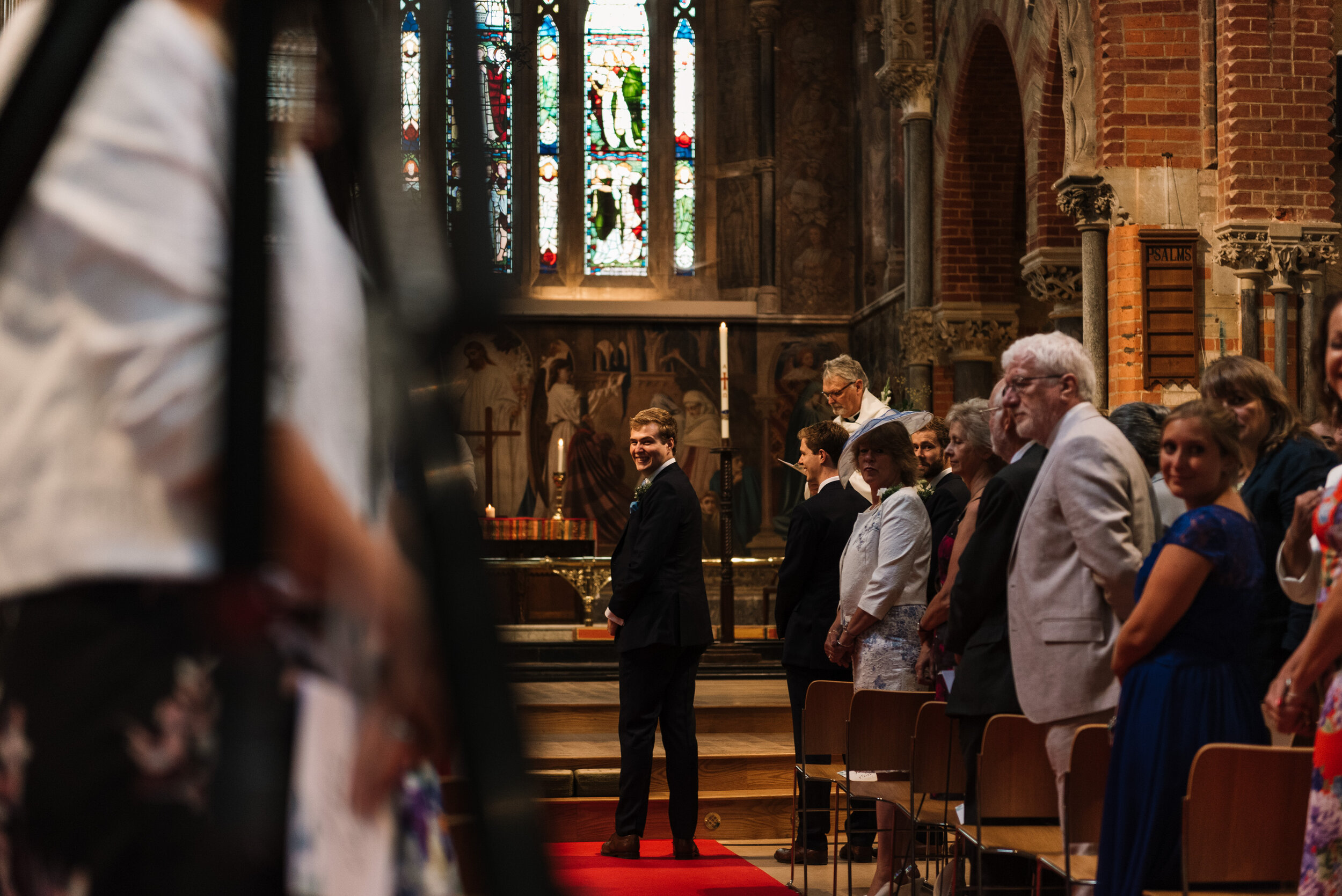 Groom turning around to look down aisle at bride