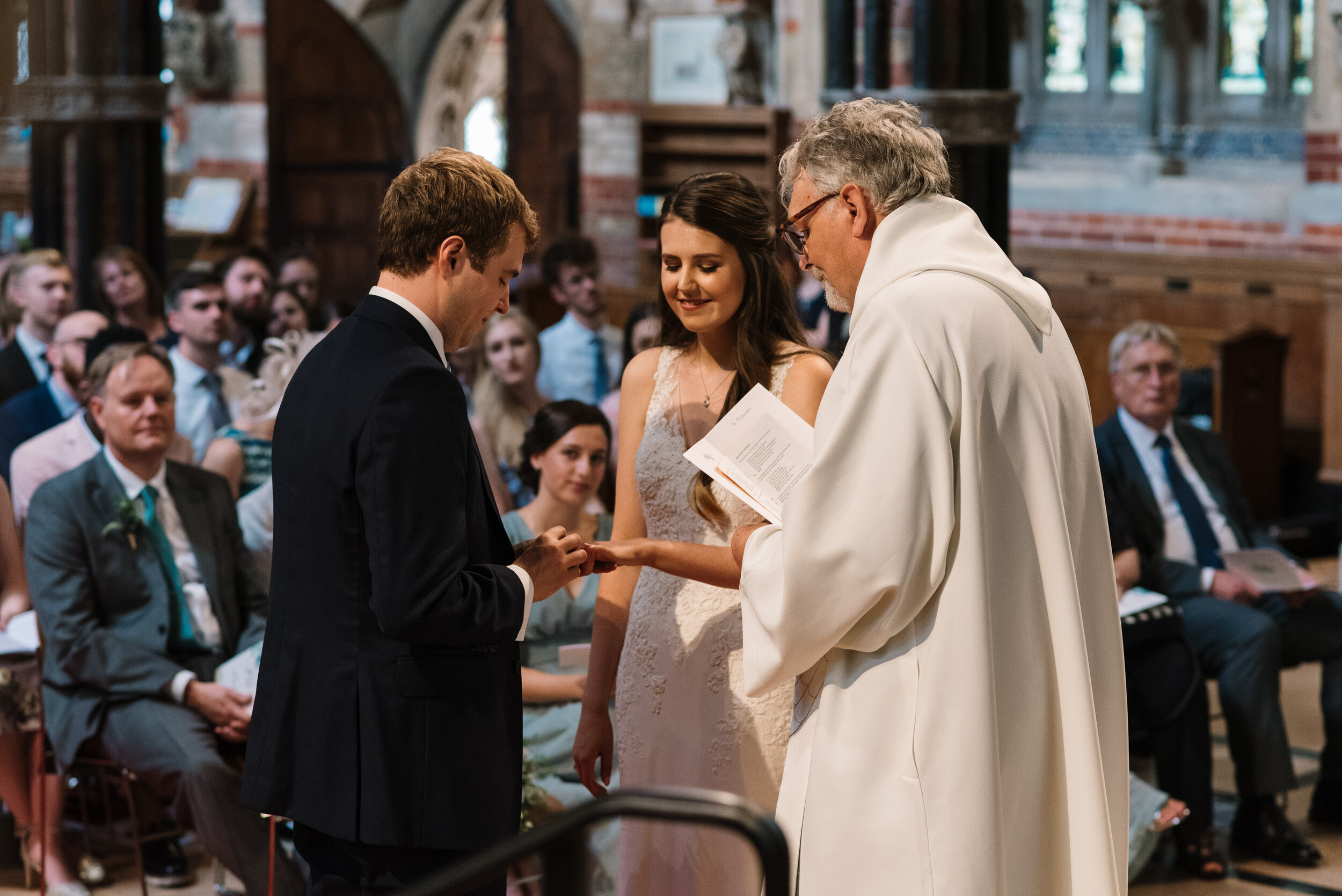 Vicar conducting vows for bride and groom in church wedding