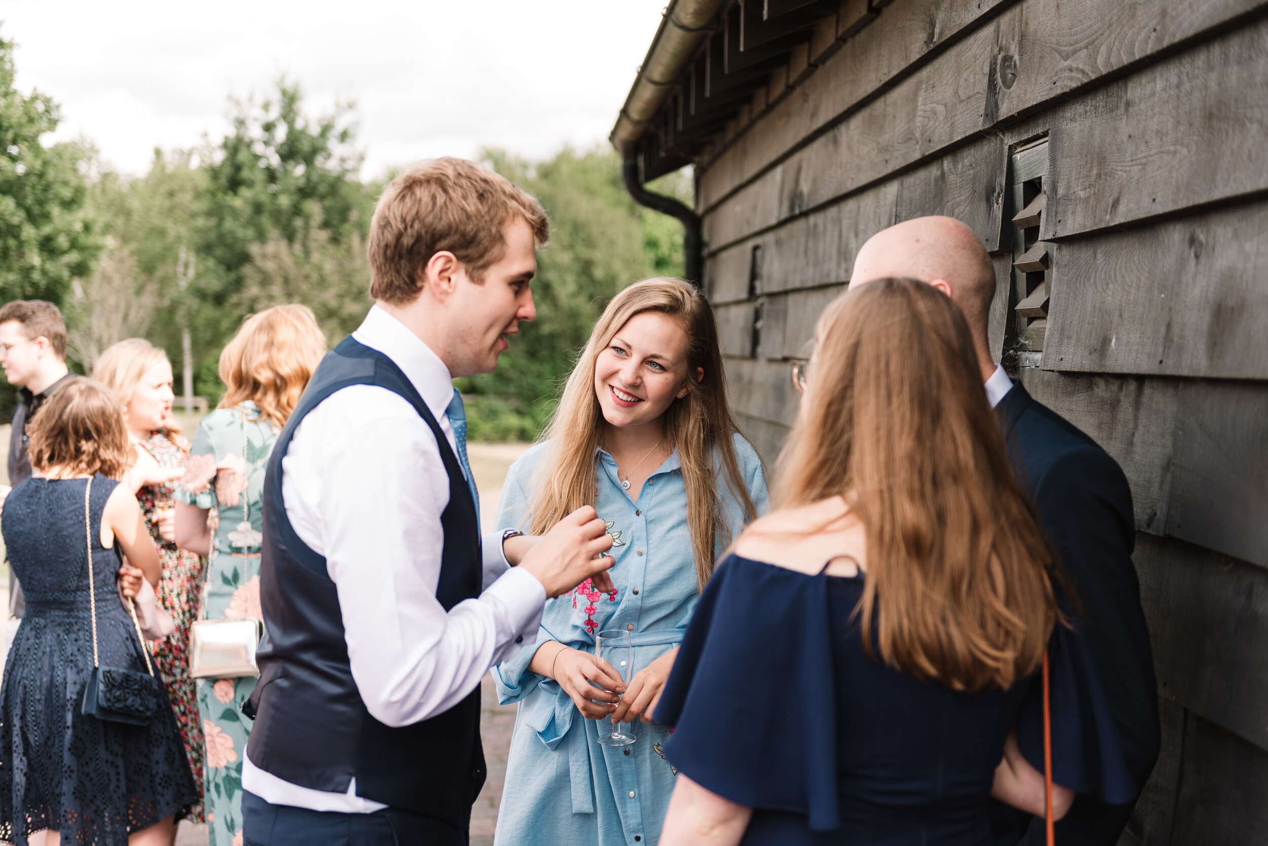 Groom talking to guests outside at wedding reception