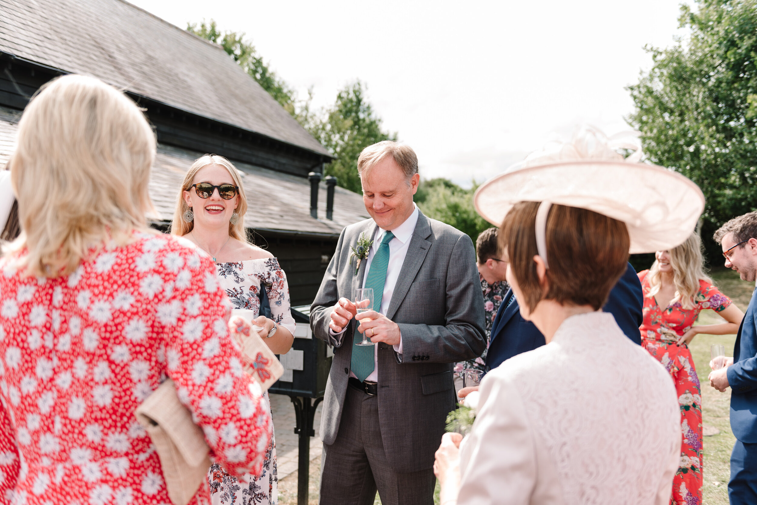 Group of wedding guests chatting outside at Hanger Farm