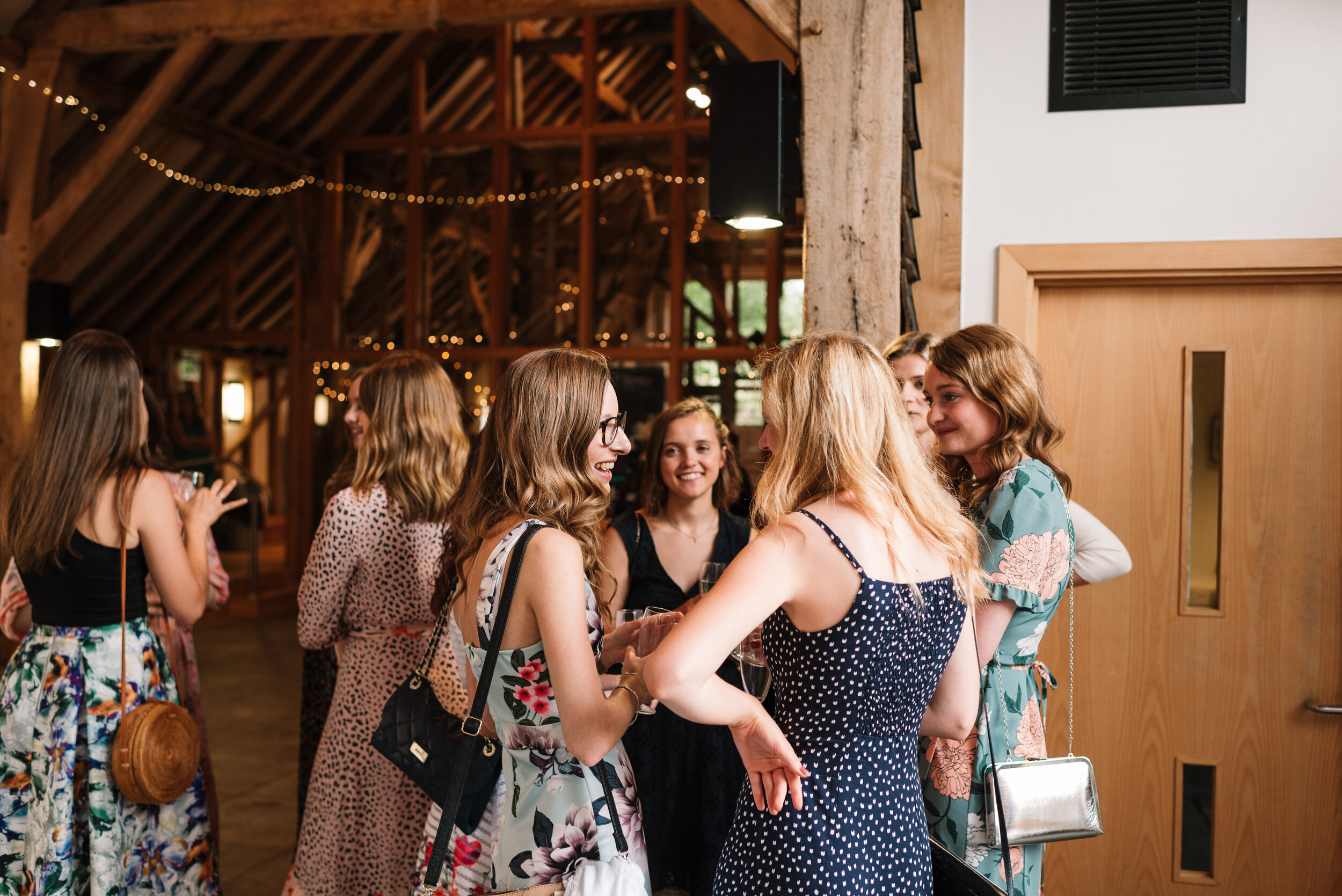 Group of female wedding guests chatting inside Hanger Farm