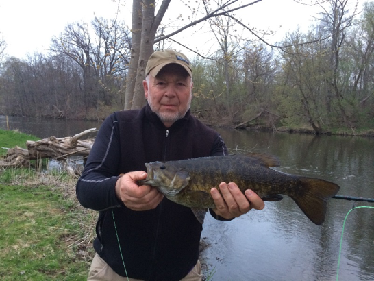 Photo: Mark with an impressive 19” smallie caught in early May 2016. Mark used a weighted crayfish streamer pattern (Skyes craw).