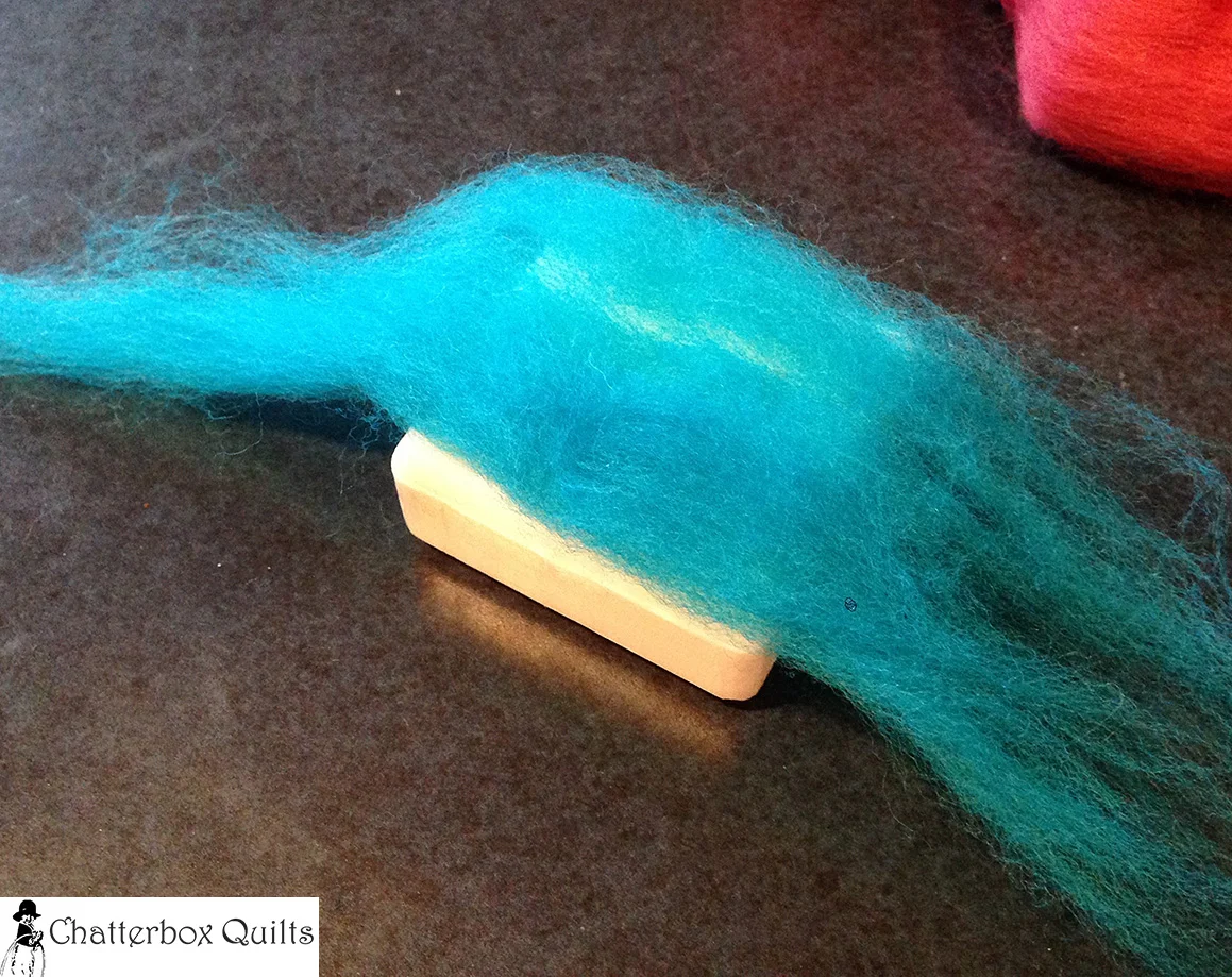 First piece of wool roving applied to one side of the soap