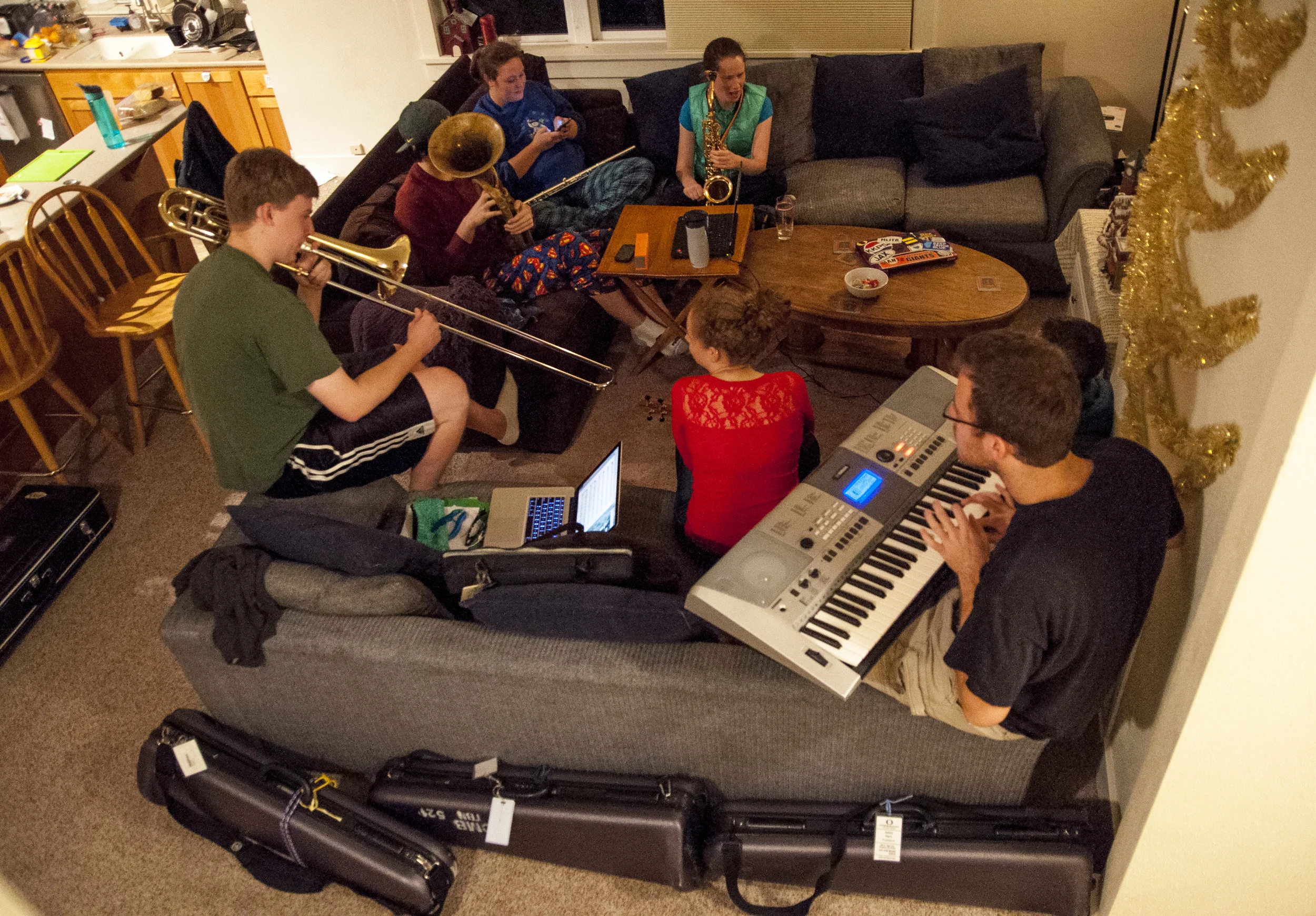 Having decided to go caroling door to door before they return home for winter break, the roommates gather together for an impromtu practice session. (Clockwise starting at the bottom right) Timmy Beick on piano, Kylee Striplin on ukelele, Doug Beick on trombone, Harrison Allen-Sutter on euphonium, Hannah Giardina on flute, and Jenny Horn on saxophone have all been member of the Oregon Marching Band and are University of Oregon students.