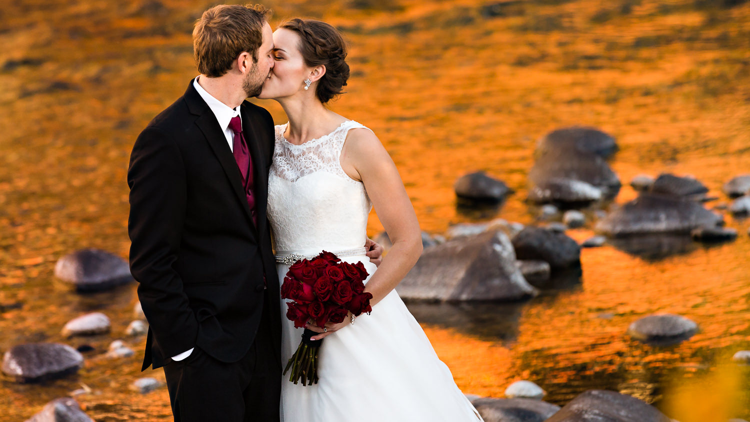 absaroka-beartooth-wilderness-montana-wedding-reception-couple-kissing-along-orange-fall-river.jpg