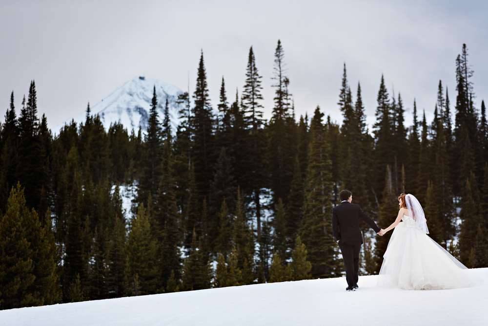 big-sky-montana-winter-wedding-breanna-first-look-bride-groom-walking-over-snow.jpg
