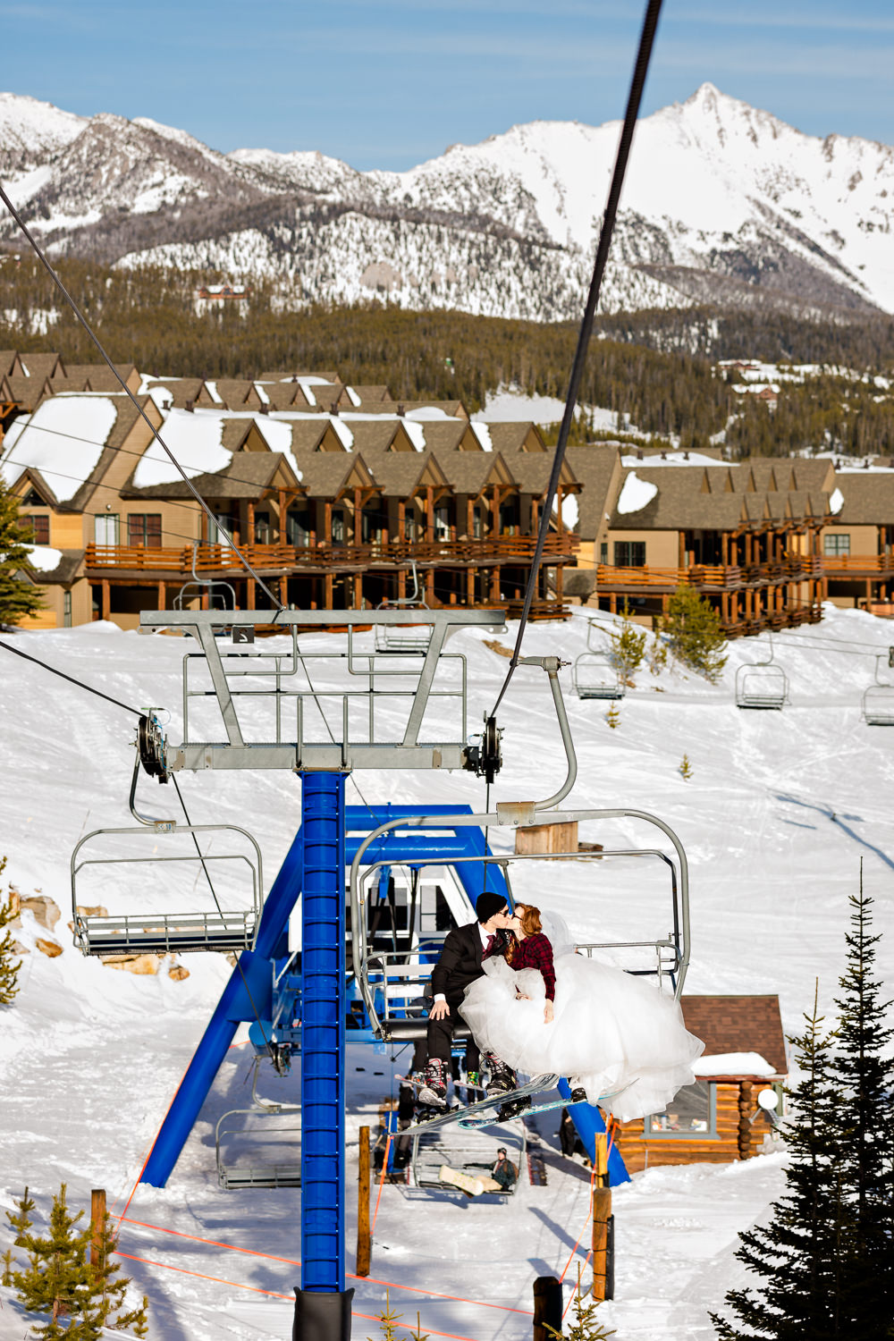 big-sky-montana-winter-wedding-breanna-formals-bride-groom-kiss-on-chairlift.jpg