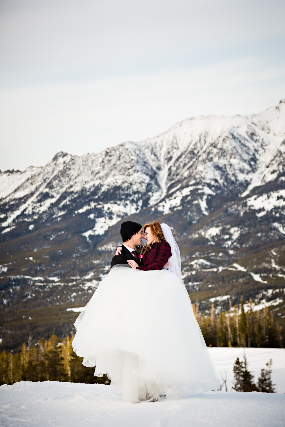 big-sky-montana-winter-wedding-breanna-formals-groom-lifts-bride-for-kiss.jpg