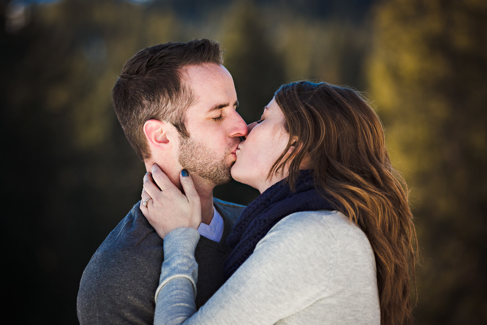 big-sky-montana-winter-engagement-session-couple-kissing-in-forest.jpg