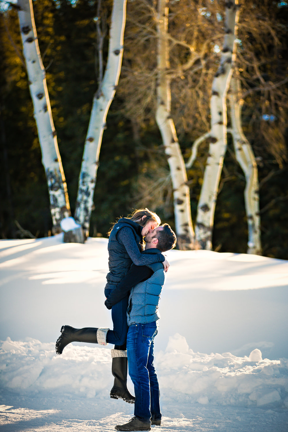 big-sky-montana-winter-engagement-session-couple-kissing-near-aspen-trees.jpg
