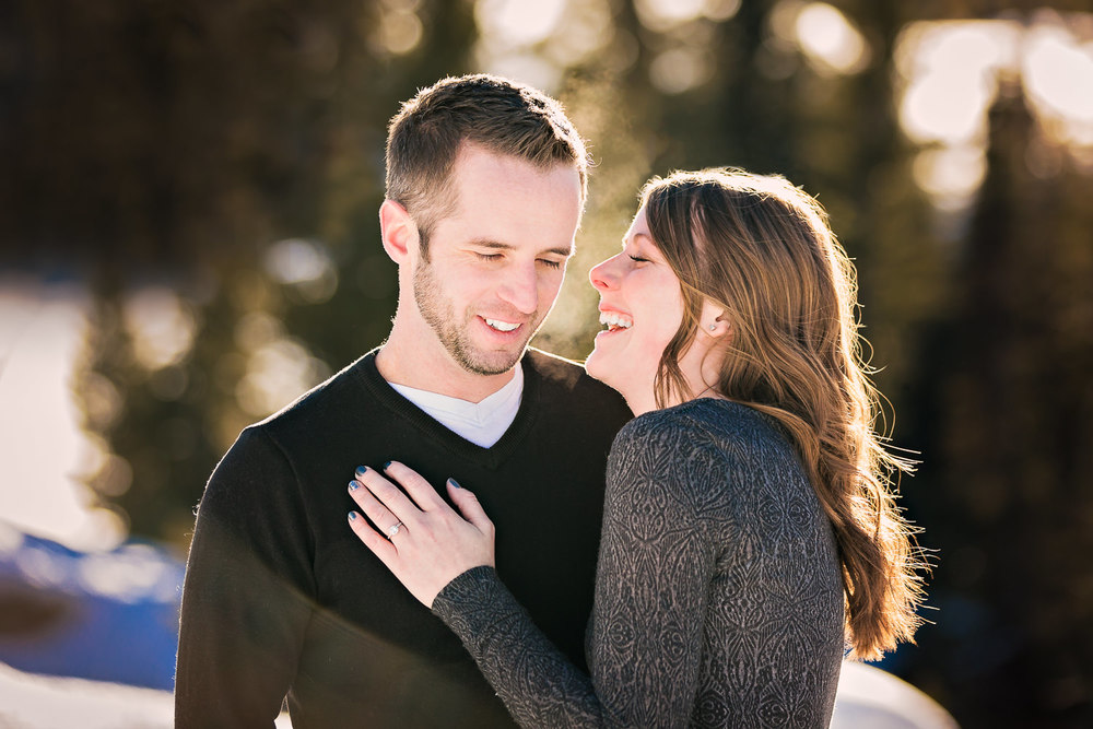 big-sky-montana-winter-engagement-session-couple-laughing in forest.jpg