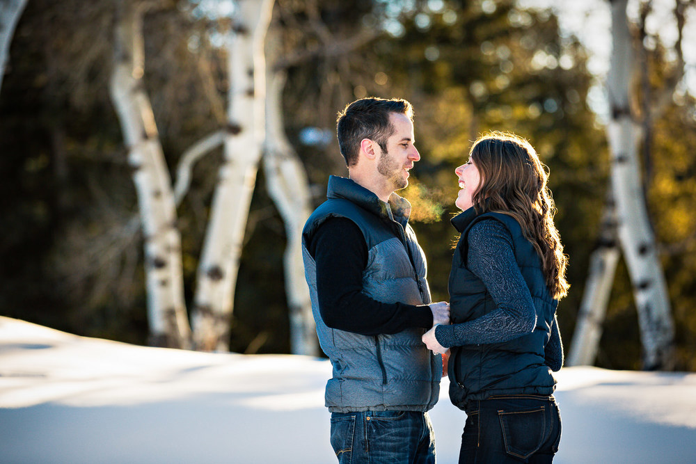 big-sky-montana-winter-engagement-session-couple-laughing-near-aspen-trees.jpg