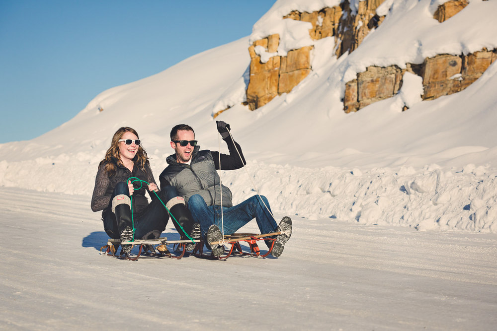 big-sky-montana-winter-engagement-session-couple-sledding.jpg