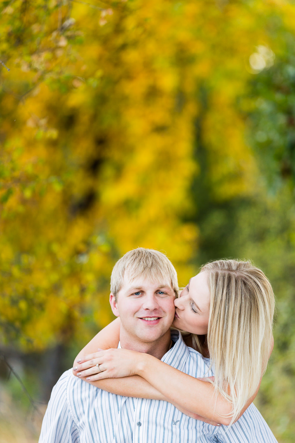 Billings-Montana-fall-engagement-woman-kissing-man's-cheek.jpg