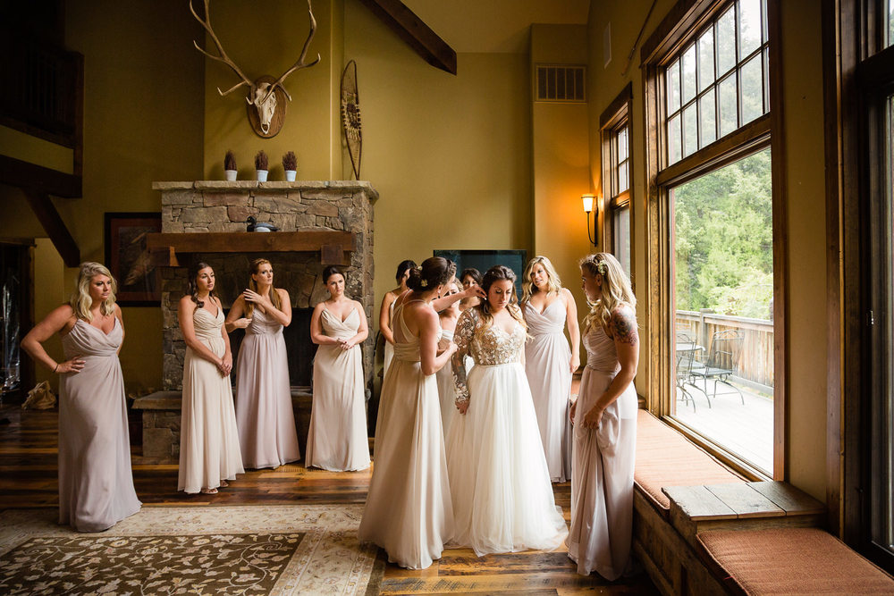 bozeman-hart-ranch-wedding-bridesmaids-help-bride-get-dressed.jpg