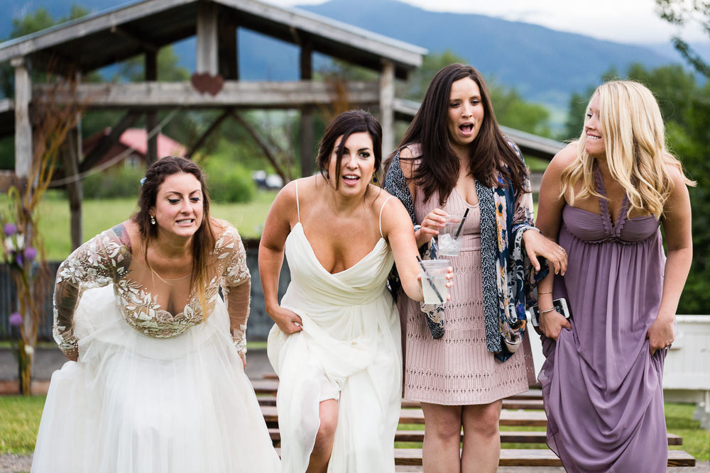 bozeman-hart-ranch-wedding-bride-jumps-off-bench-with-friends.jpg