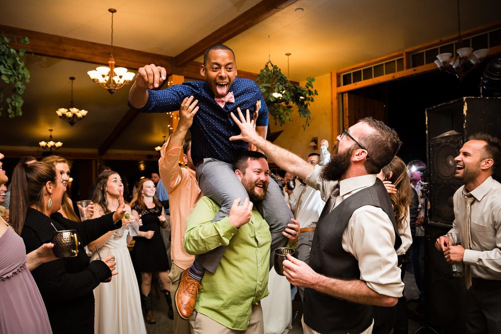 bozeman-hart-ranch-wedding-guests-dance-with-man-on-shoulders.jpg
