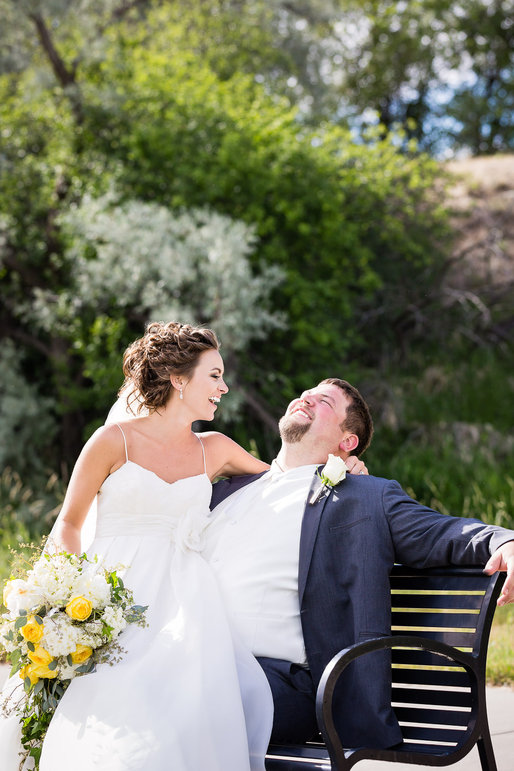 billings-montana-swift-river-ranch-wedding-reception-couple-laughing-on-bench.jpg