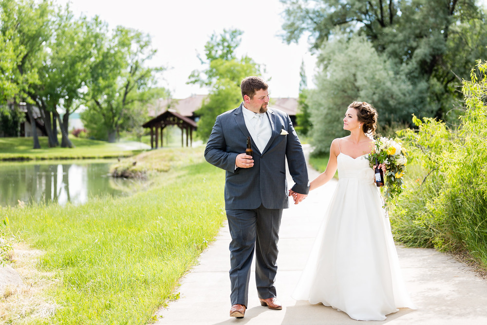 billings-montana-swift-river-ranch-wedding-reception-couple-walks-with-beer.jpg