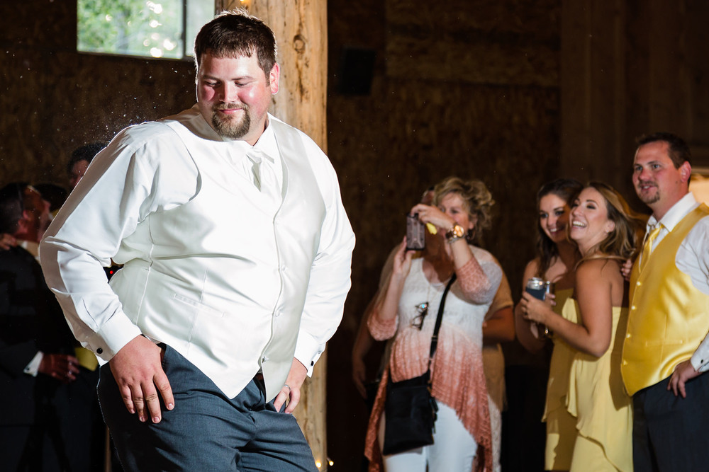 billings-montana-swift-river-ranch-wedding-reception-groom-makes-moves-before-garter-toss.jpg