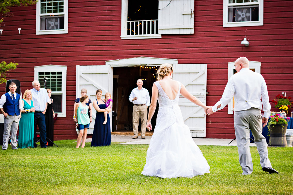 bozeman-montana-wedding-roys-barn-bride-groom-hold-hands-during-reception.jpg