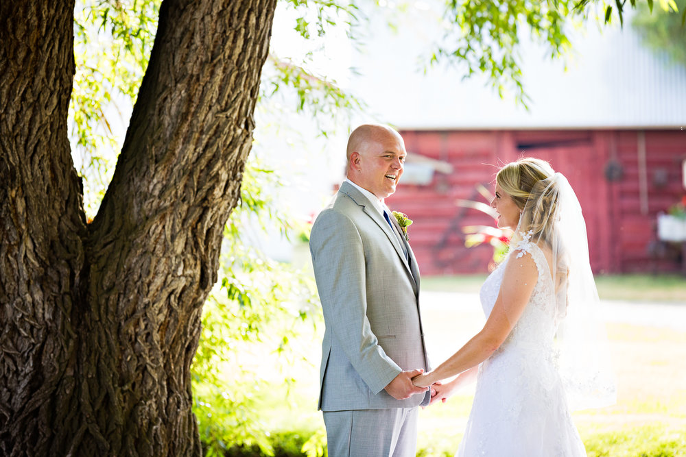 bozeman-montana-wedding-roys-barn-bride-groom-laugh-hold-hands.jpg