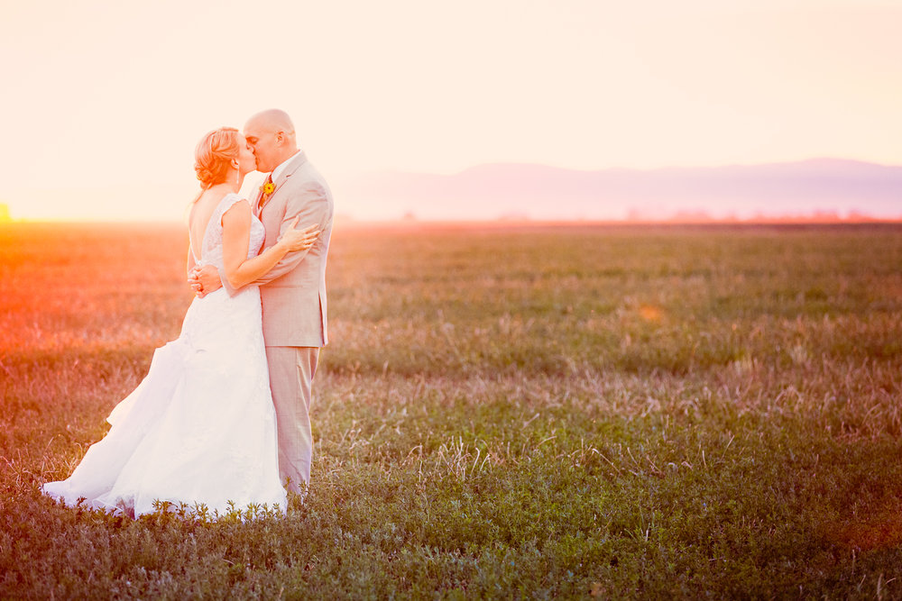 bozeman-montana-wedding-roys-barn-couple-kisses-under-orange-sunset.jpg