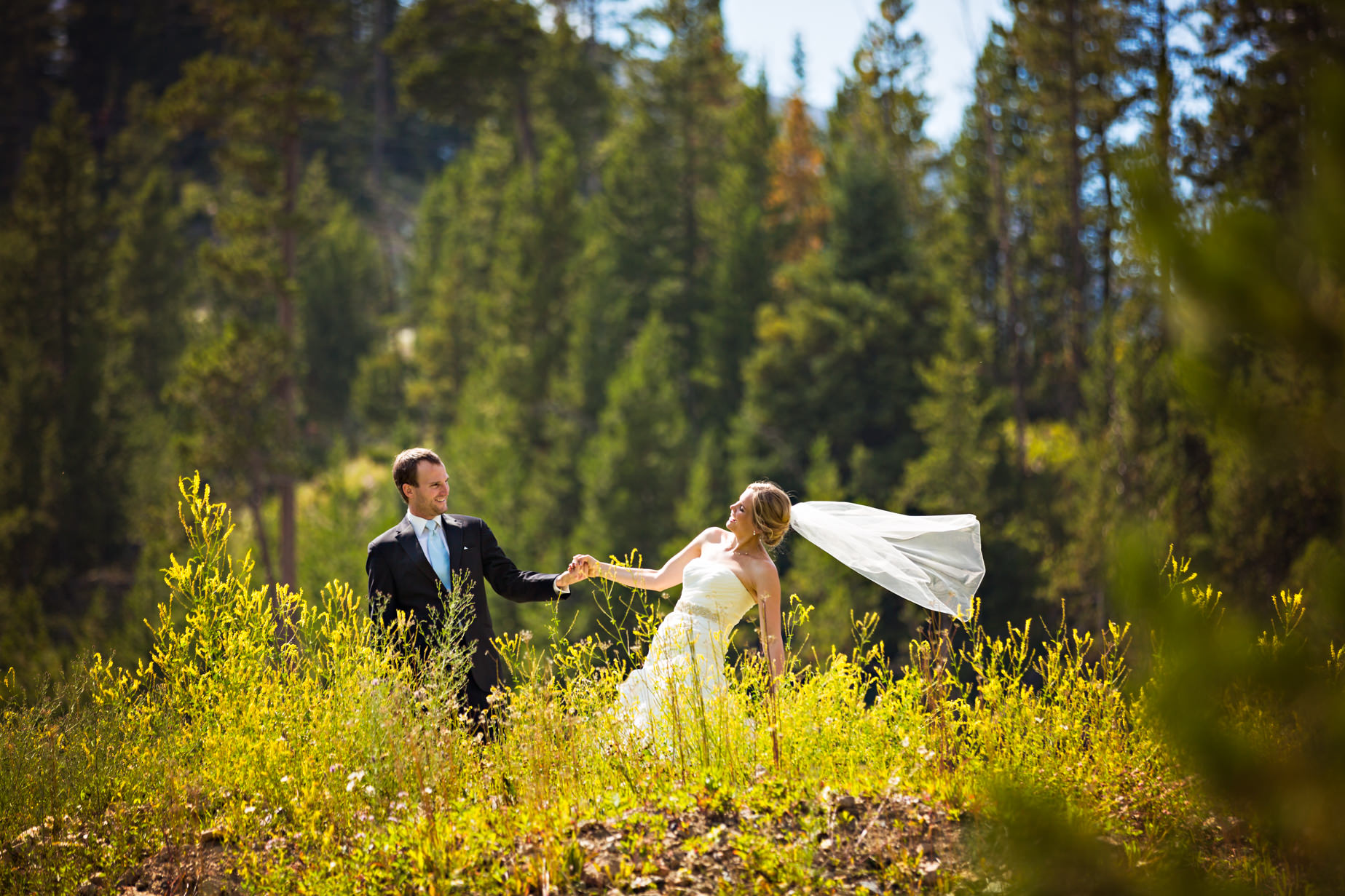 big-sky-resort-wedding-groom-pulls-brides-hand.jpg