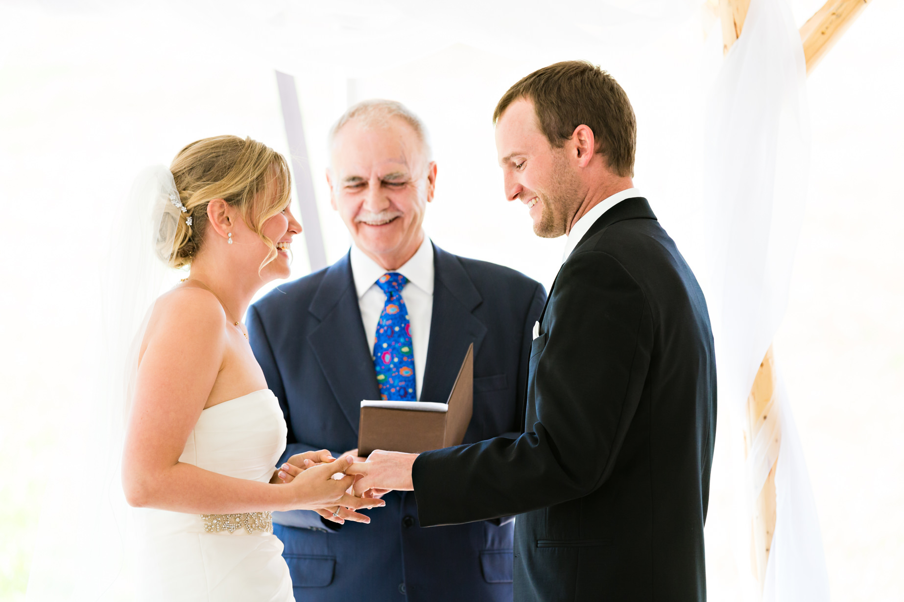 big-sky-resort-wedding-bride-groom-laugh-during-ring-exchange.jpg