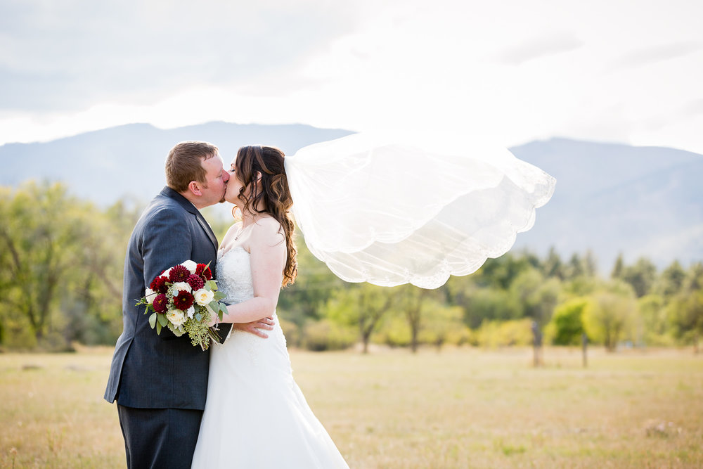 heritage-hall-missoula-montana-bride-groom-kissing-while-veil-flies.jpg