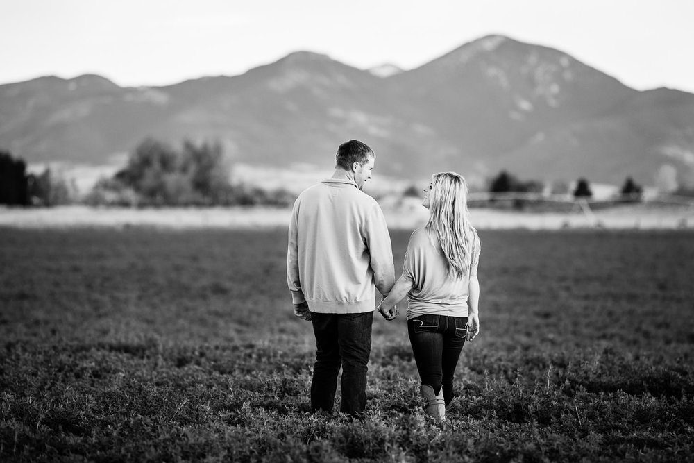 bozeman-montana-engagement-session-couple-walking-through-field-mountains.jpg