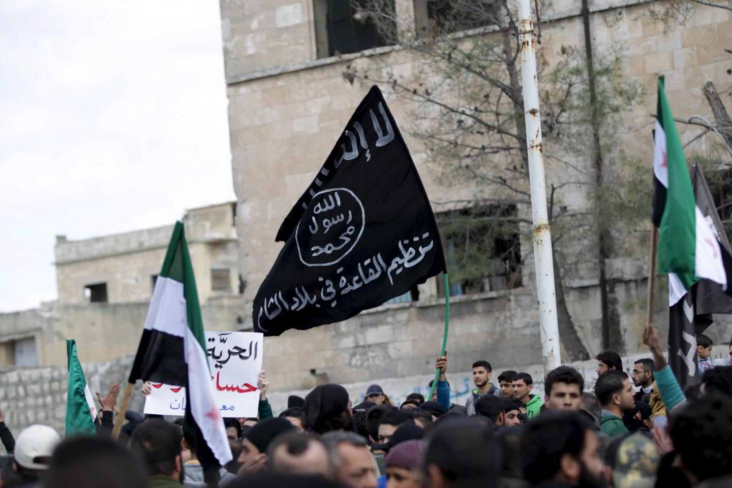 "Protesters carry Al-Qaeda and Free Syrian Army flags during an anti-government protest... in Idlib province, Syria, March 11, 2016." Courtesy of Newsweek . KHALIL ASHAWI/REUTERS