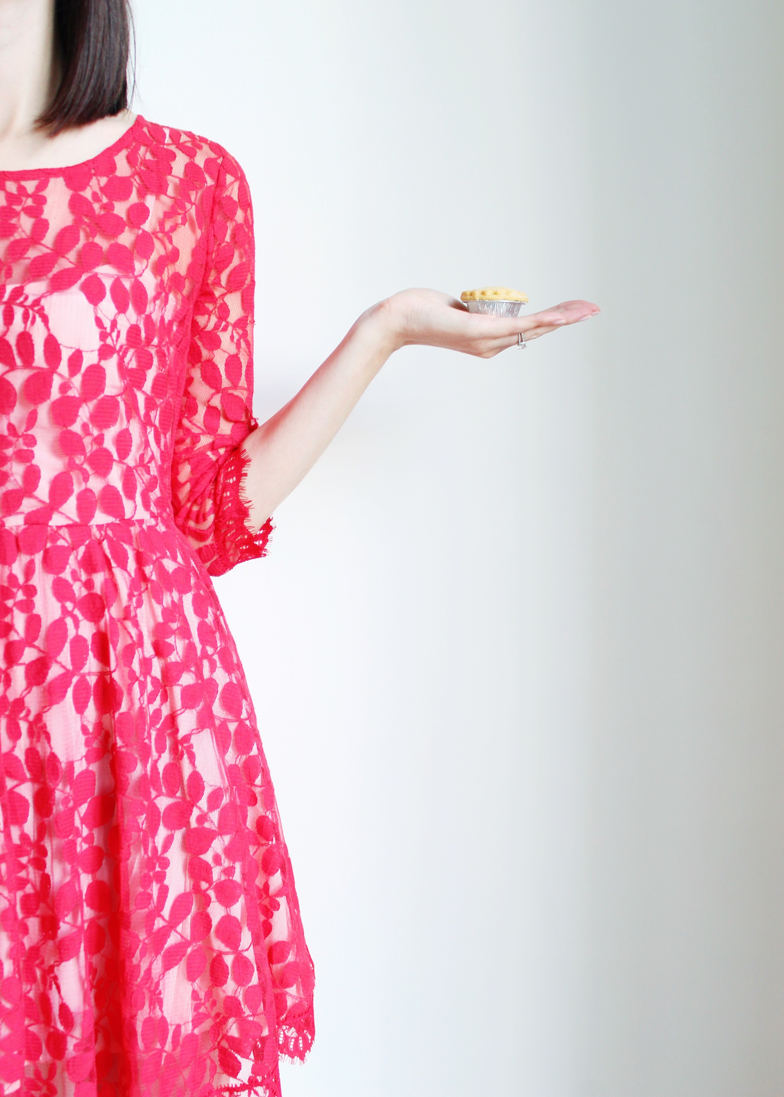 Looking festive in a red dress, holding a mince pie.