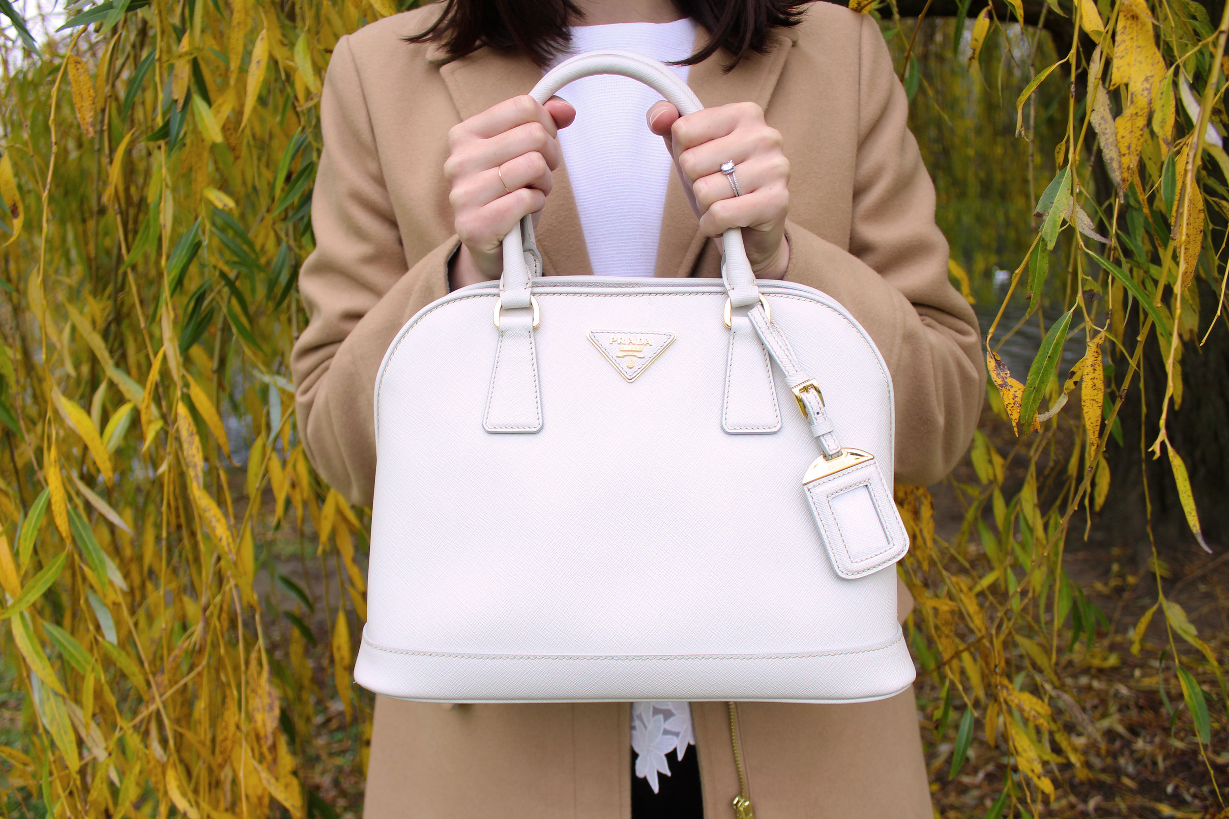 White leather Prada bag paired with a camel coat from Topshop.