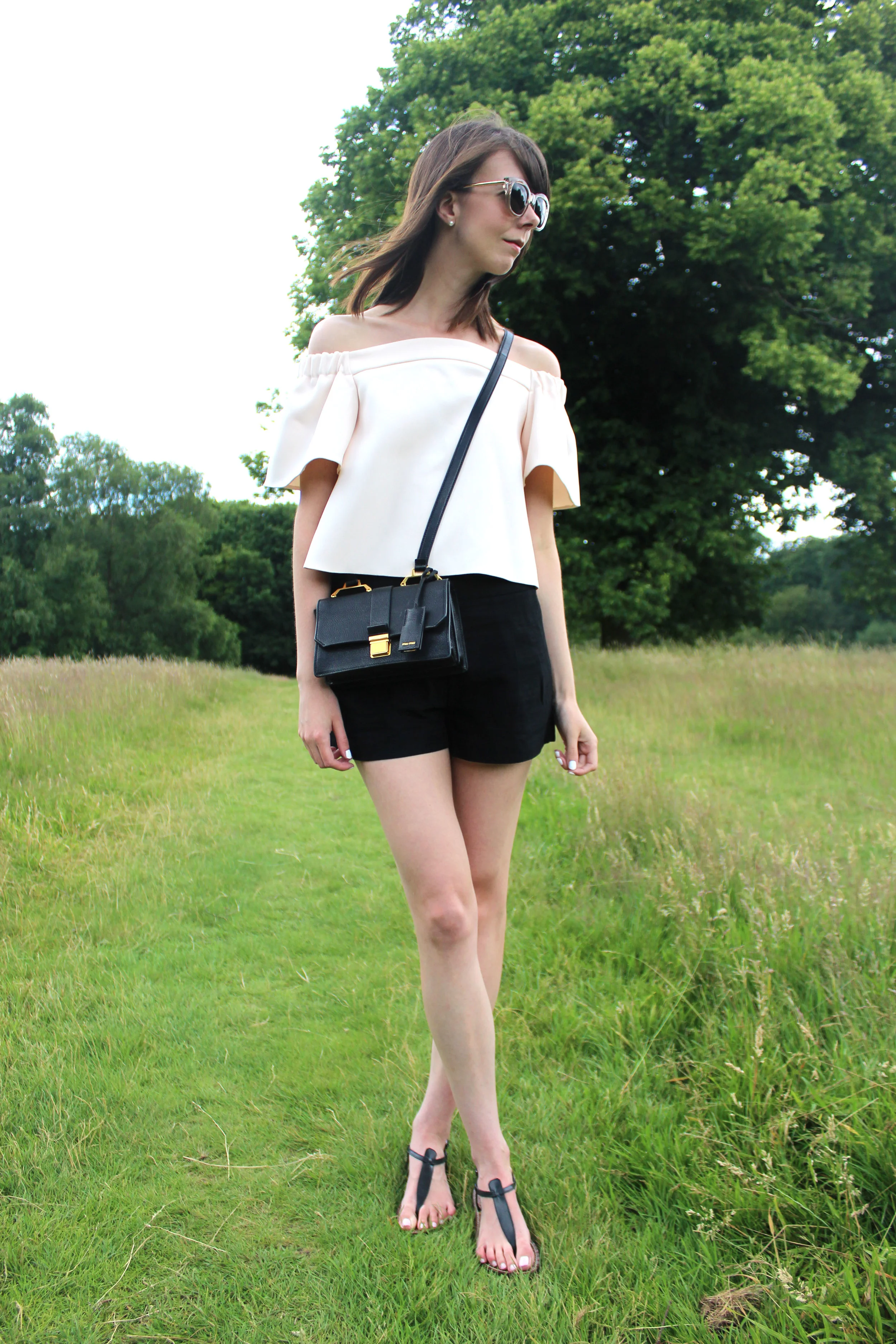 Hampstead Heath, London wearing an off the shoulder top and miu miu bag.