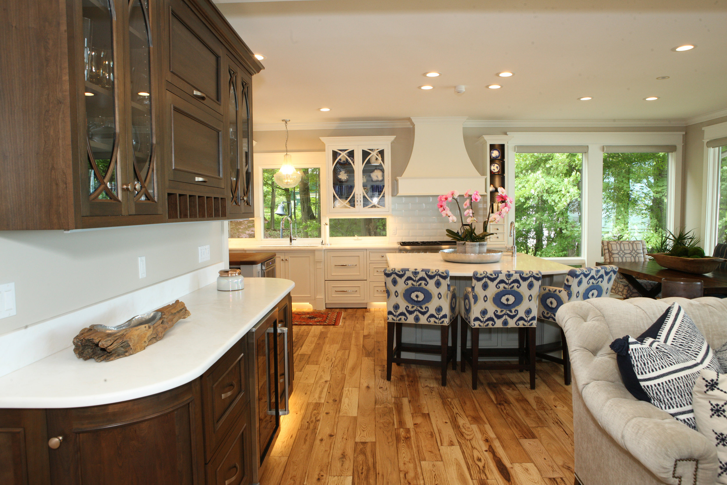 Warm hand scraped hickory floors leading up to sophisticated white cabinets, dark two-tone interiors. 