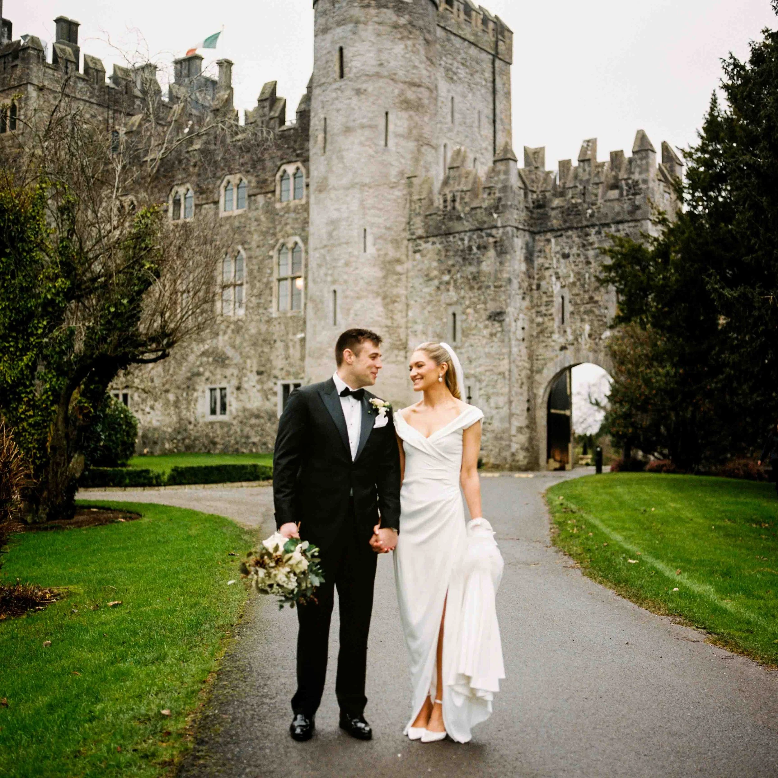 medium format analog photo of couple walking away from kilkea castle