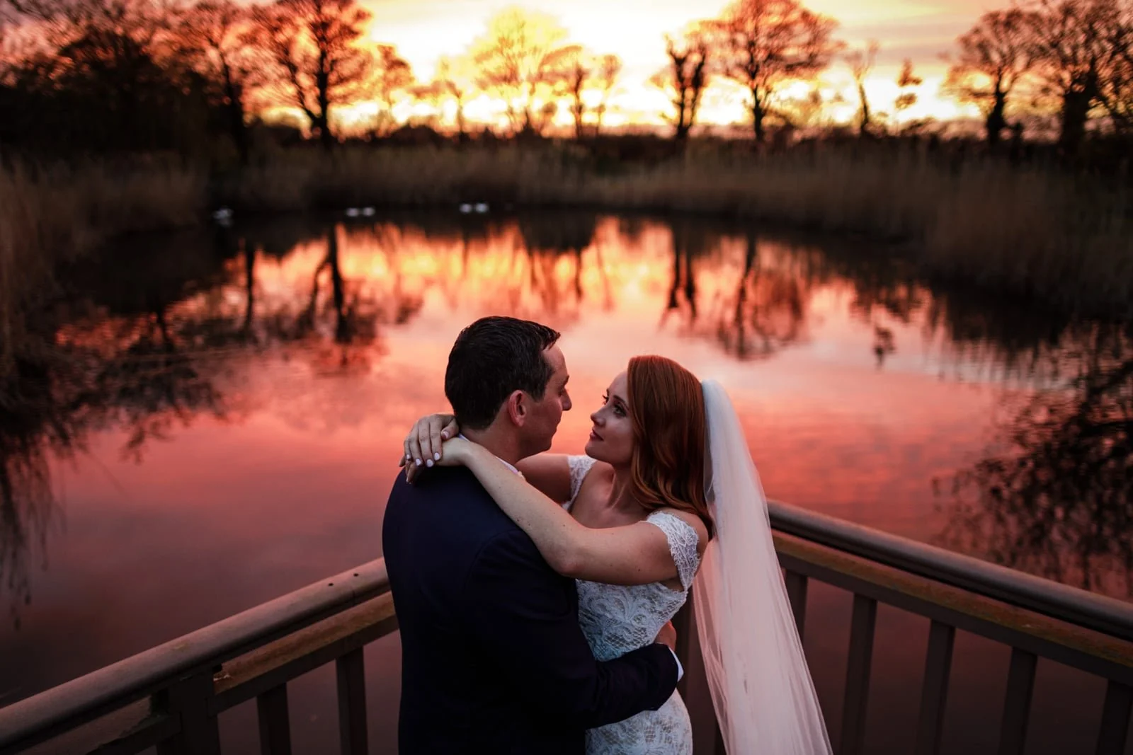 Couple embracing by the water at sunset at Ballymagarvey Village