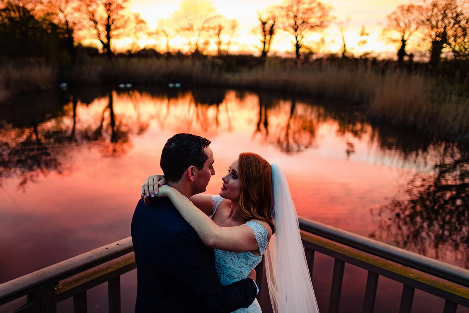 dramatic sunset wedding photograph over the lake in Ballymagarvey village in meath