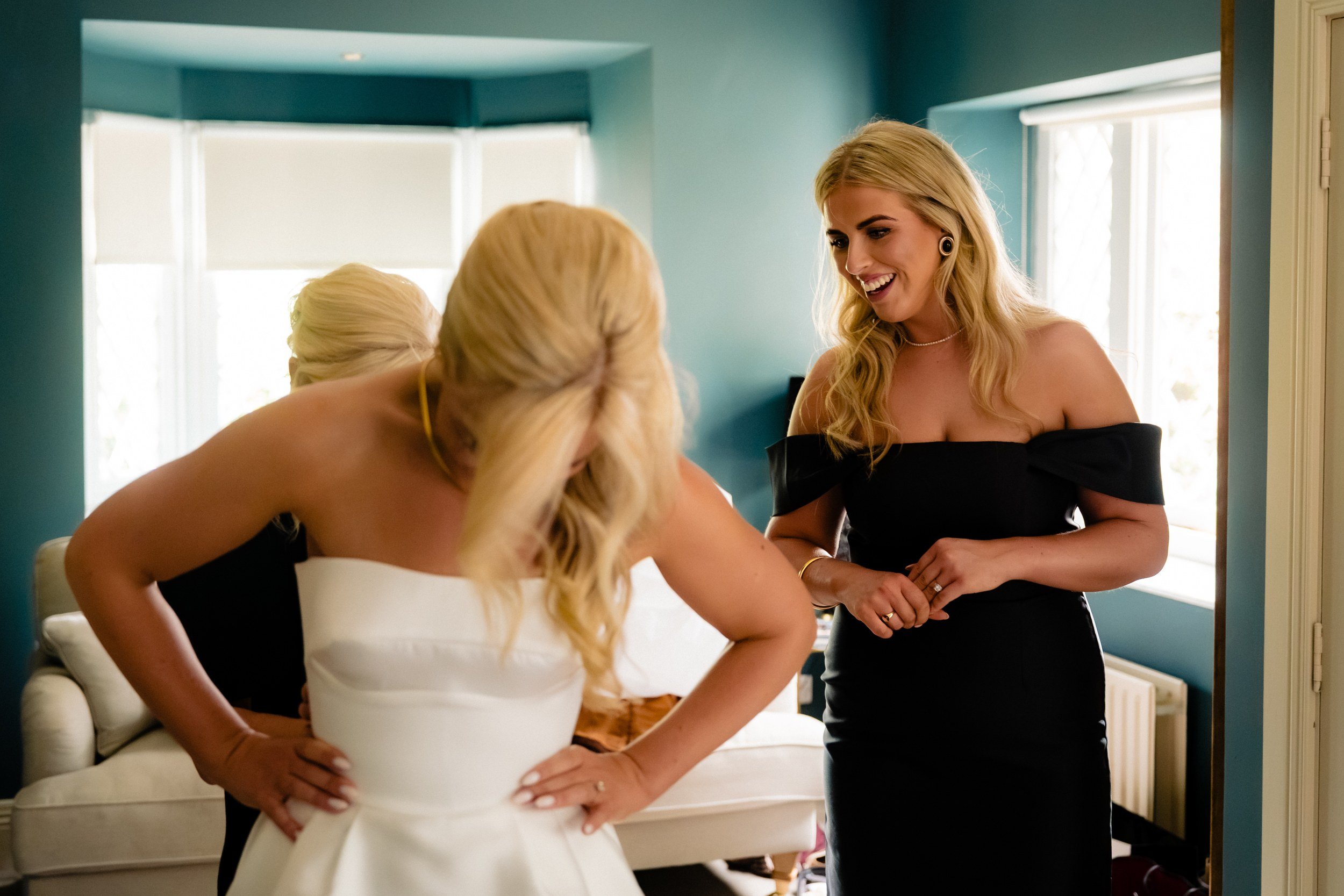 galgorm-wedding-photographer-holly-matt-09-holly-and-bridesmaid-laughing.jpg