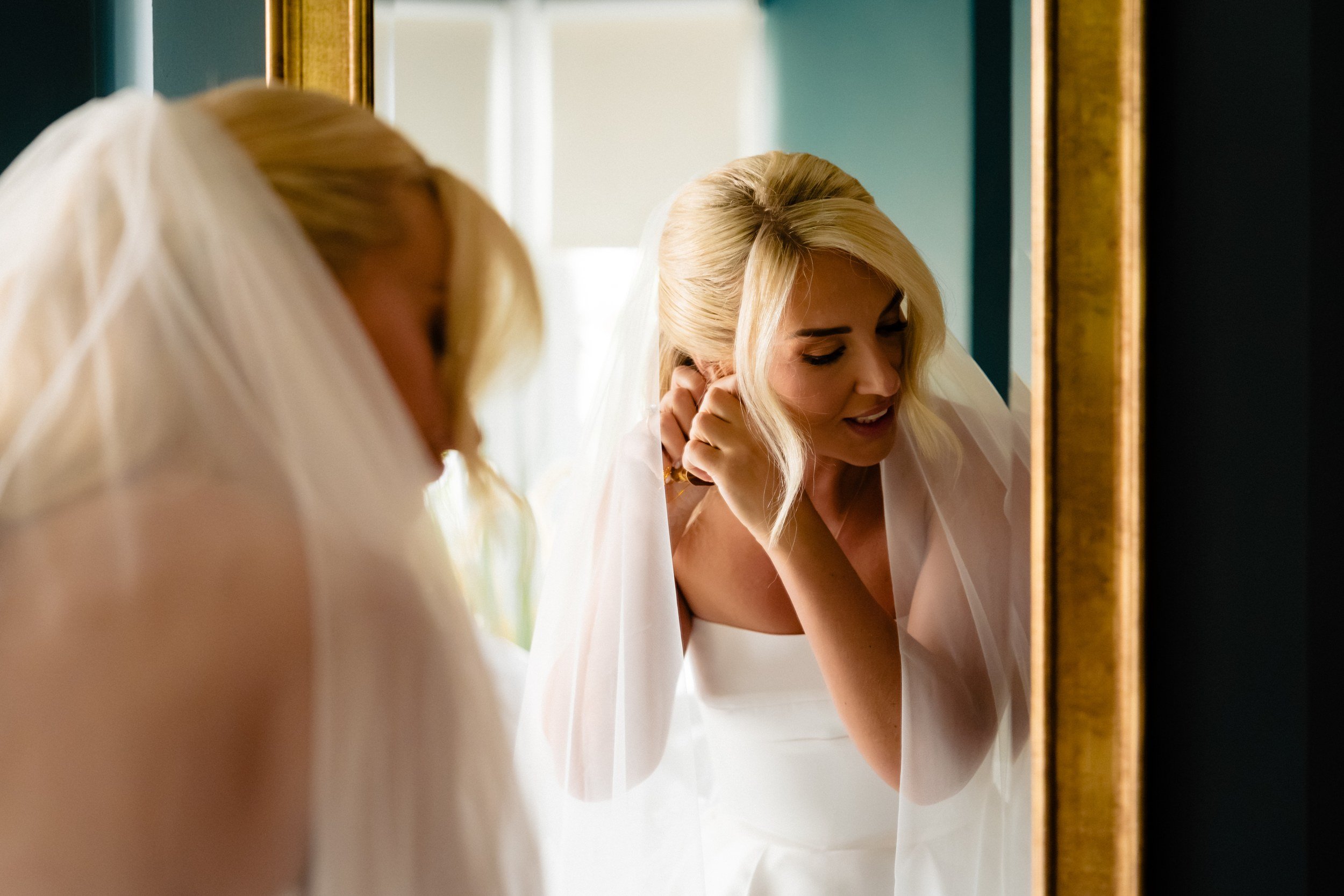 galgorm-wedding-photographer-holly-matt-12-holly-earrings-in-the-mirror.jpg