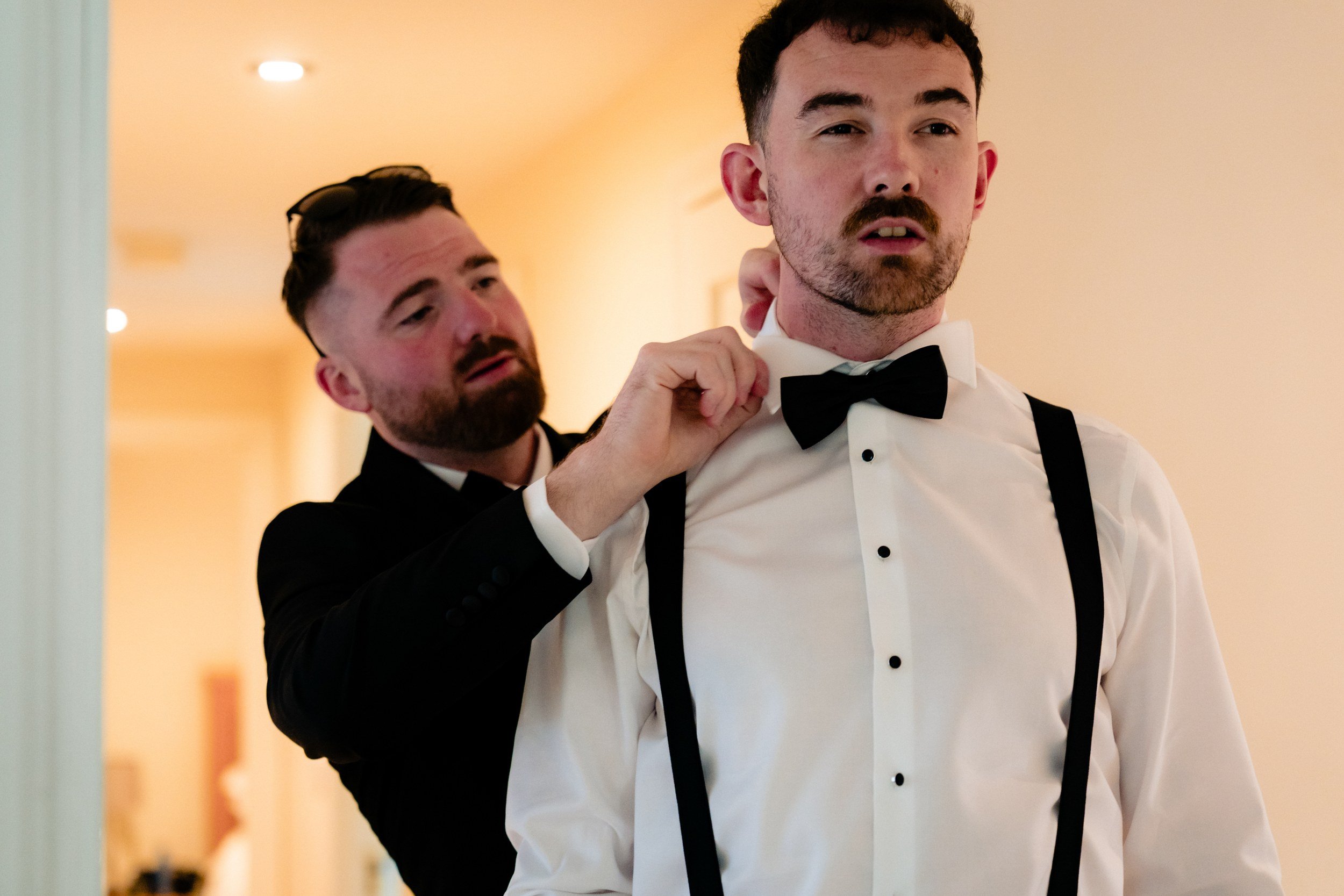 galgorm-wedding-photographer-holly-matt-16-matt-fixing-his-bow-tie.jpg