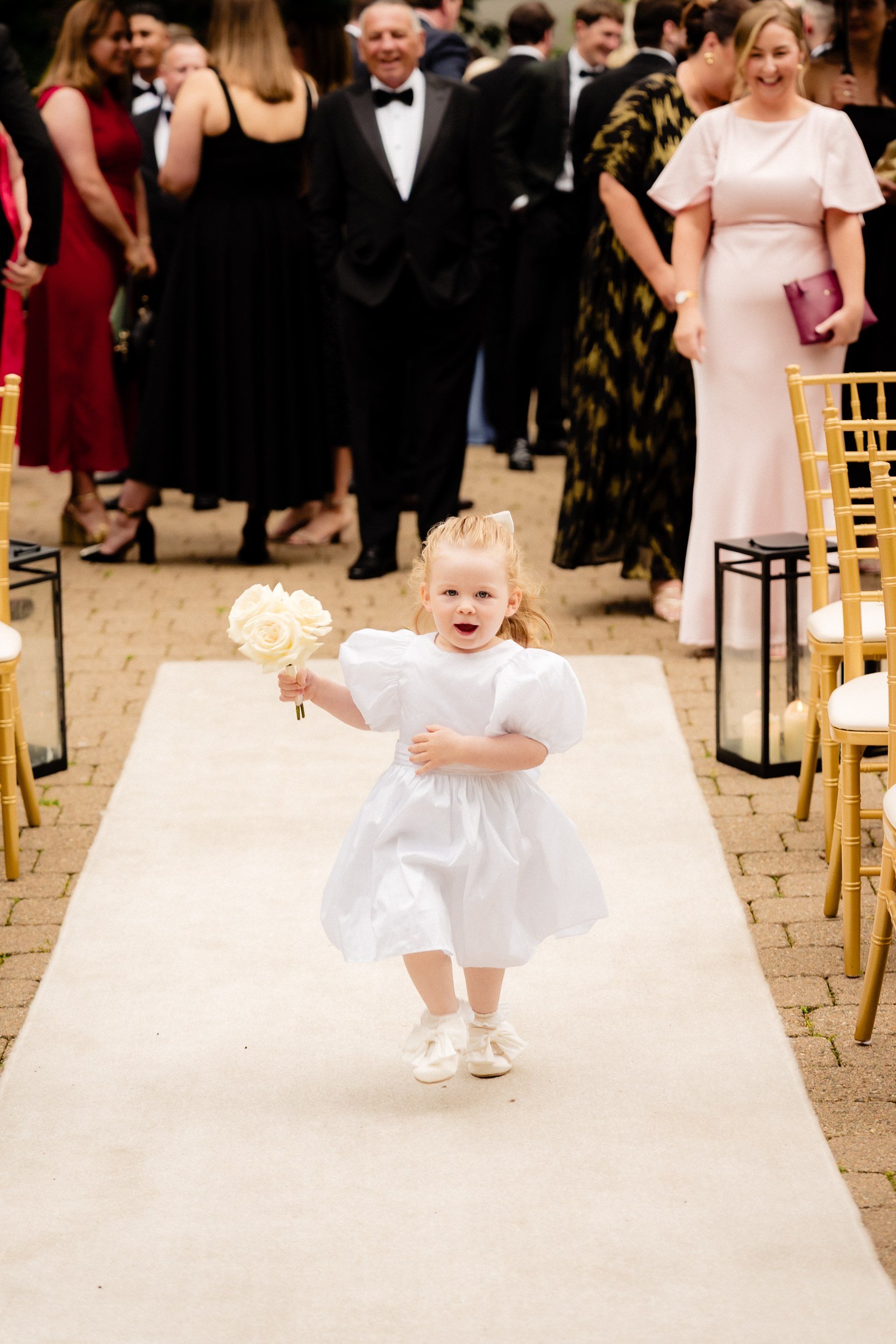 galgorm-wedding-photographer-holly-matt-26-flower-girl-running-the-aisle.jpg