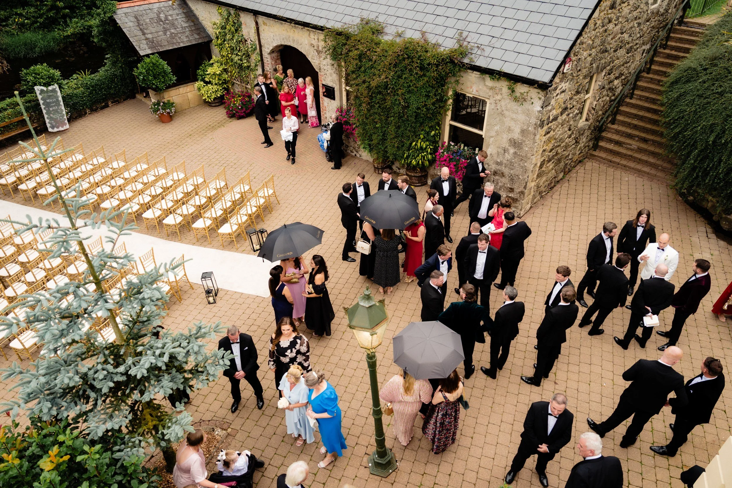 galgorm-wedding-photographer-holly-matt-25-courtyard-umbrellas-from-above.jpg