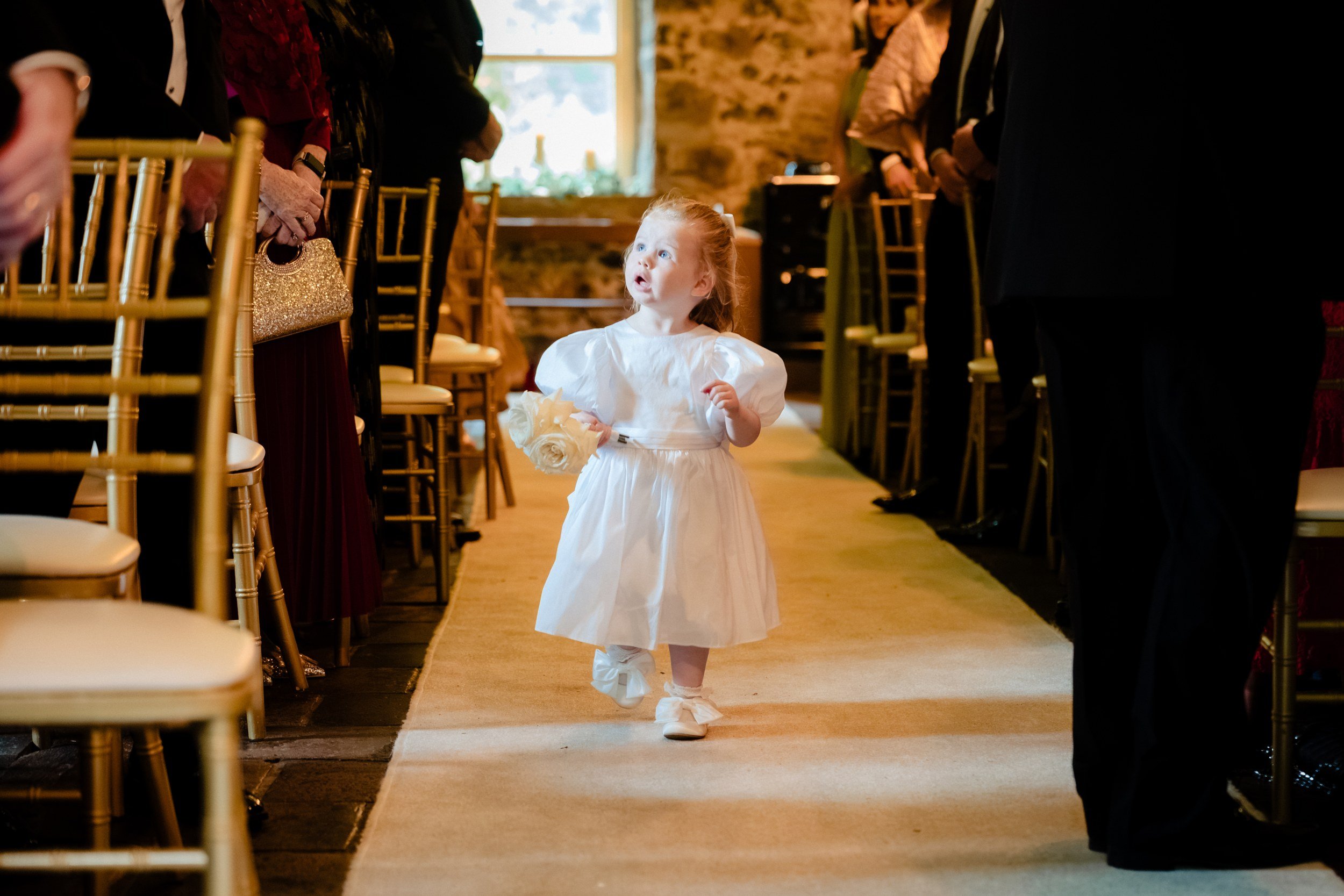 galgorm-wedding-photographer-holly-matt-31-flower-girl-walking-the-aisle.jpg