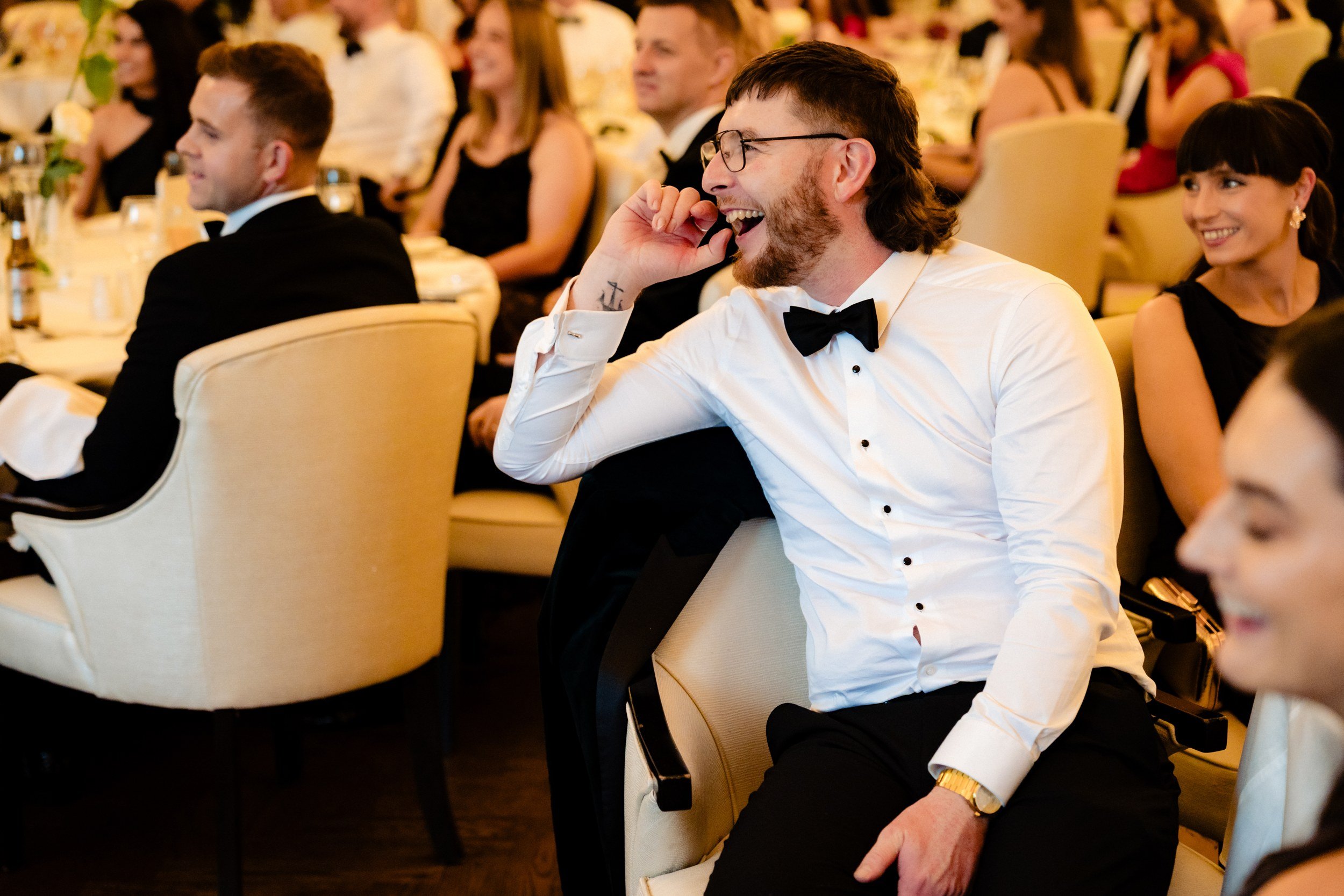 galgorm-wedding-photographer-holly-matt-56-guest-laughing-during-speeches.jpg